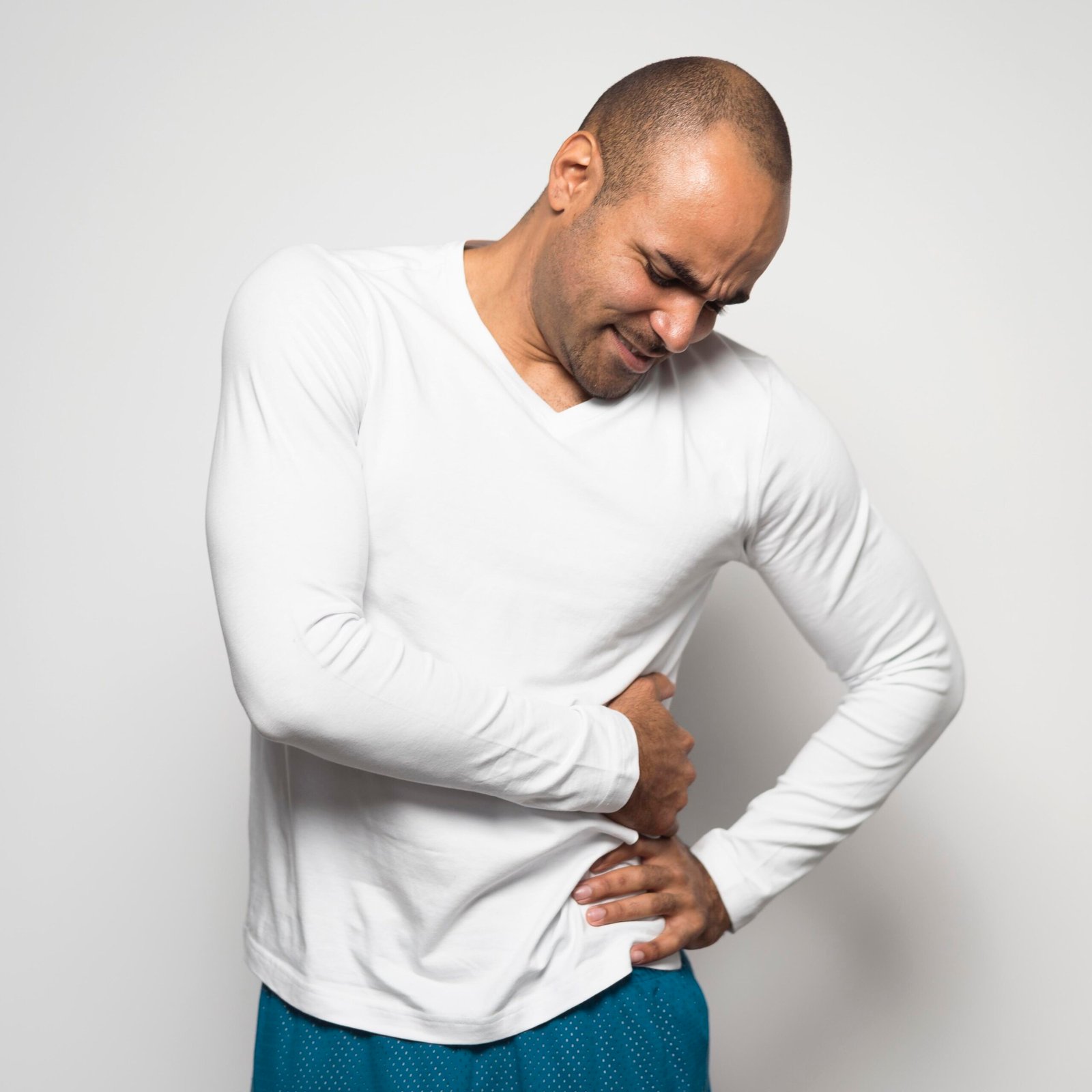 Man clutching his side in pain, potentially indicating symptoms of cystic kidney disease or kidney-related discomfort.