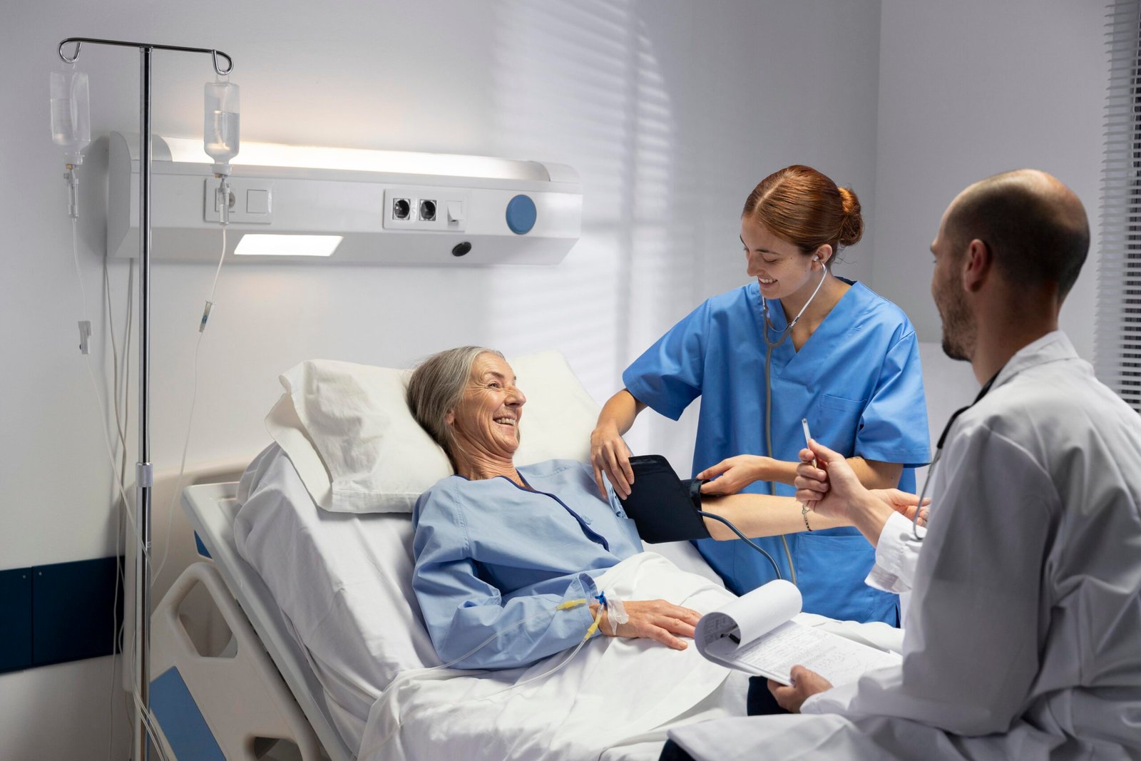 Elderly female patient receiving care from medical team in a hospital bed during dialysis treatment